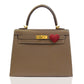 Brown handbag with a gold clasp and red heart charm on a white background, collection-preview