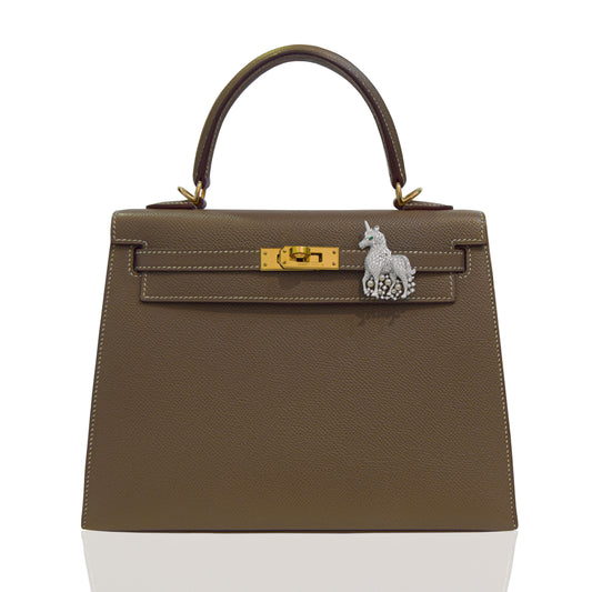 Brown handbag with gold hardware and a unique clasp on a white background, collection-preview