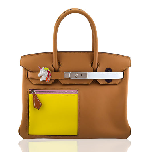 Brown handbag with a yellow patch and unicorn charm on a white background, collection-preview