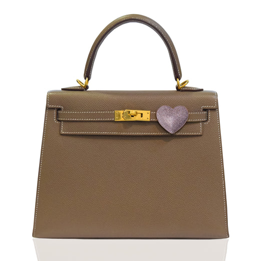 Brown handbag with a heart-shaped clasp on a white background, collection-preview