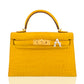 Yellow crocodile skin handbag with gold hardware and a white logo on a white background, collection-preview