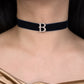 Navy velvet choker with a decorative 'B' clasp worn by a person.