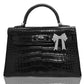 A black handbag with a crocodile pattern, featuring a silver bow custom attachment, collection-preview.