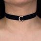 Navy blue velvet choker with a silver clasp on a person's neck against a black background