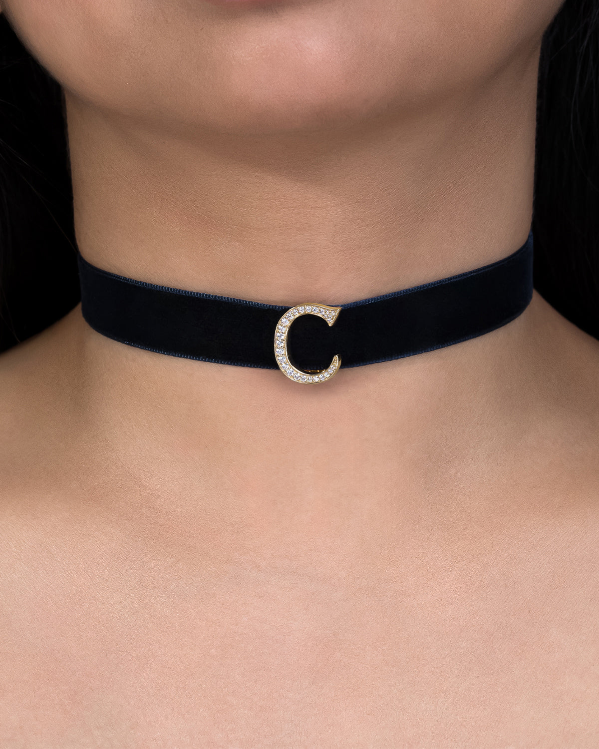 Navy blue velvet choker with a silver crescent moon pendant on a person's neck.