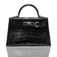 A black handbag with a crocodile pattern and a metallic clasp, resembling a high-end leather handbag, collection-preview.