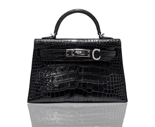 A black handbag with a crocodile pattern and a metallic clasp, resembling a high-end leather handbag, collection-preview.