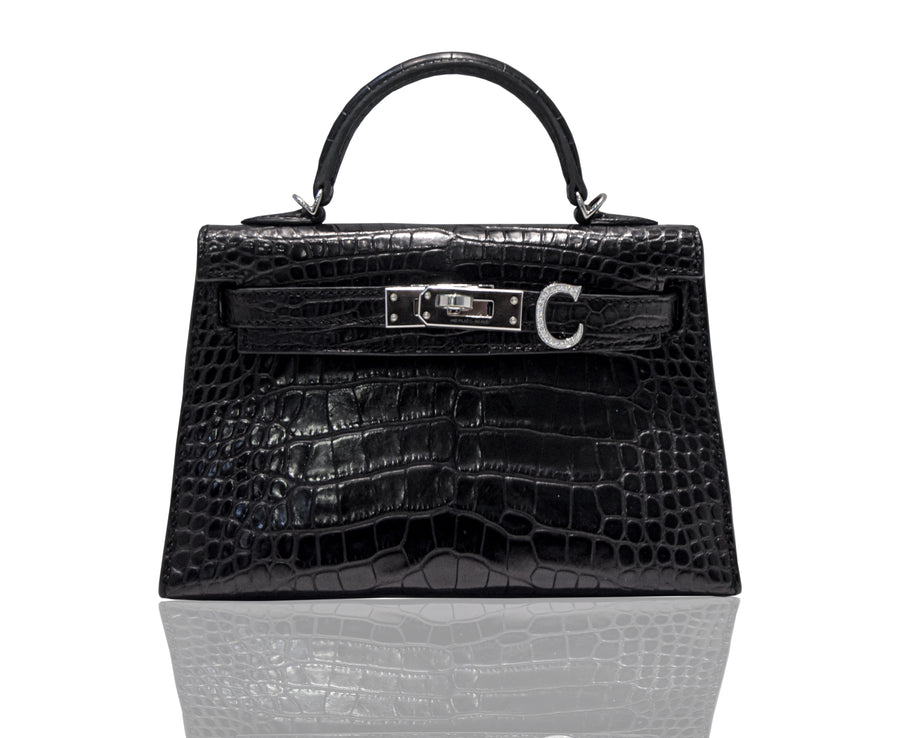 A black handbag with a crocodile pattern and a metallic clasp, resembling a high-end leather handbag, collection-preview.