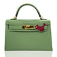 Green handbag with pink flower accessory on a white background, collection-preview