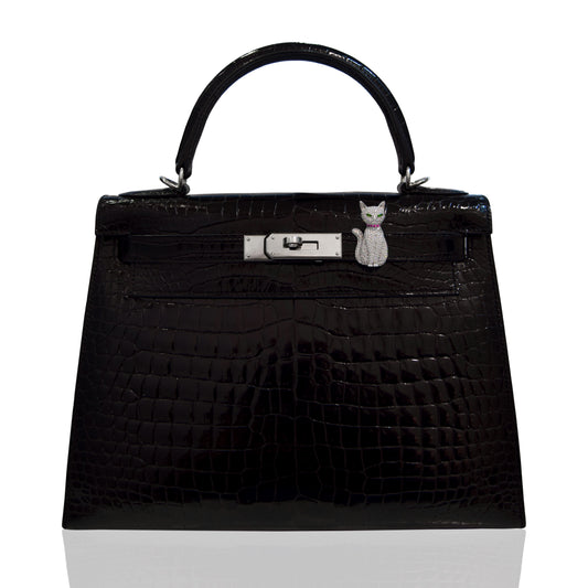 Black textured handbag with a silver clasp and cat charm on a white background, collection-preview