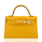 Yellow crocodile skin handbag with gold hardware on a white background, collection-preview