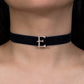 Navy blue velvet choker with a gold 'E' clasp on a person's neck.