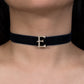 Black choker necklace with a gold 'E' clasp on a person's neck.