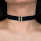 Navy blue choker with a gold 'H' pendant on a person's neck.