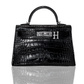 A black handbag with a crocodile pattern and a silver brooch with the letter 'H' on the front, collection-preview.