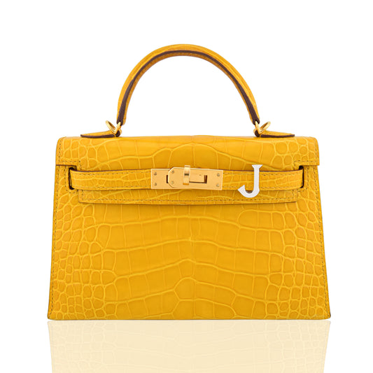 Yellow crocodile-patterned handbag with gold hardware on a white background, collection-preview