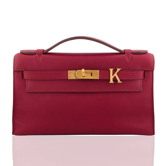 Red handbag with gold clasp on a white background, collection-preview