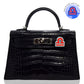 Black crocodile-patterned handbag with a distinctive clasp on a white background, collection-preview