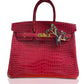 A luxurious red handbag with a crocodile pattern, featuring a gold clasp and a charm with a lovebirds design inlaid with multicolored gemstones, collection-preview.