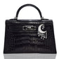 Black textured handbag with moon and star accessory on a white background, collection-preview

