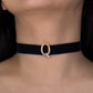 Black choker with a gold clasp worn by a person