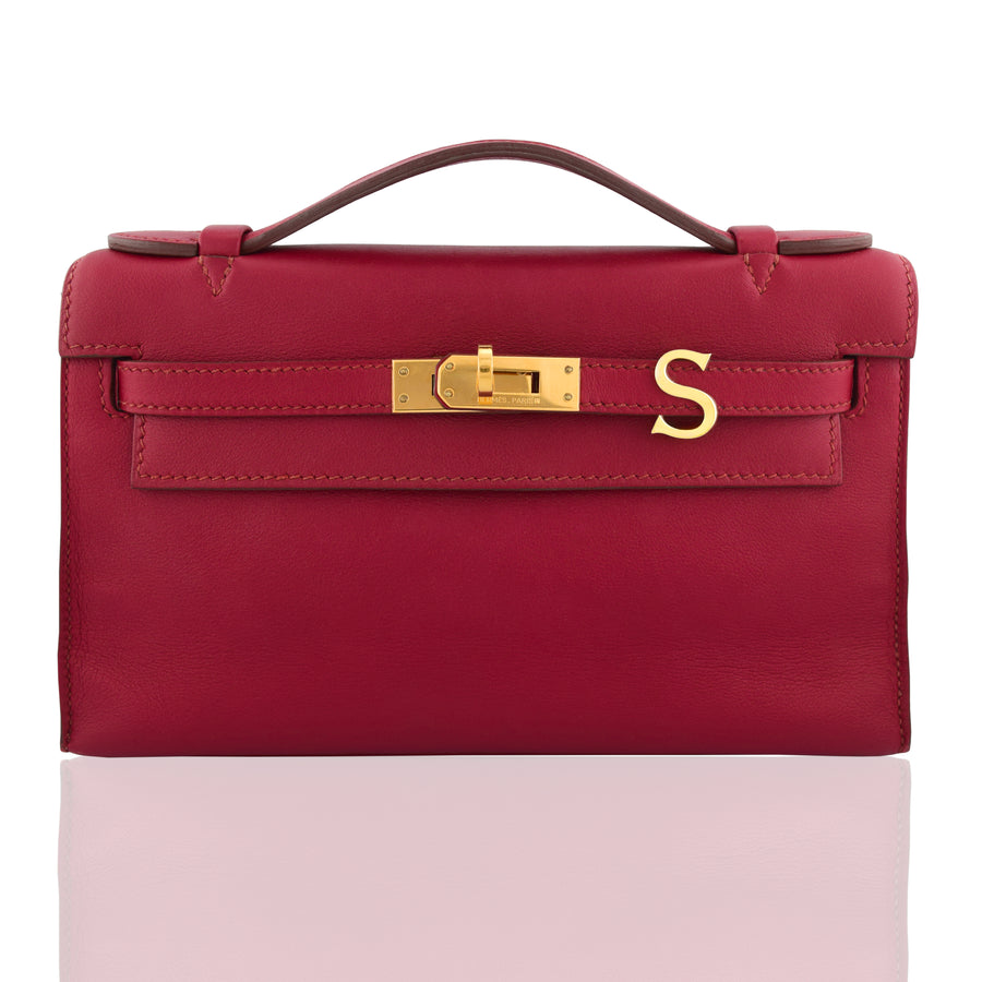Red handbag with gold clasp on a white background, collection-preview