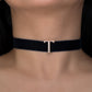 Black choker necklace with a gold clasp on a person's neck