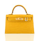 Yellow crocodile skin handbag with gold hardware on a white background, collection-preview