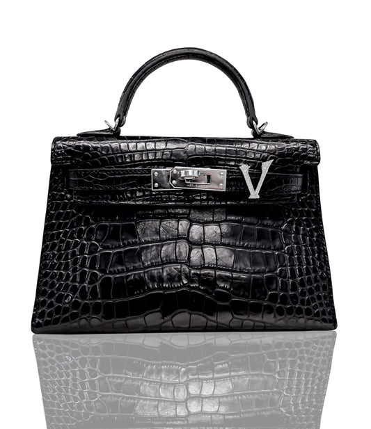 A black handbag with a crocodile pattern and a prominent 'V' letter fastener, collection-preview.