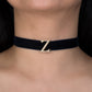 Black choker necklace with a gold 'Z' clasp on a person's neck