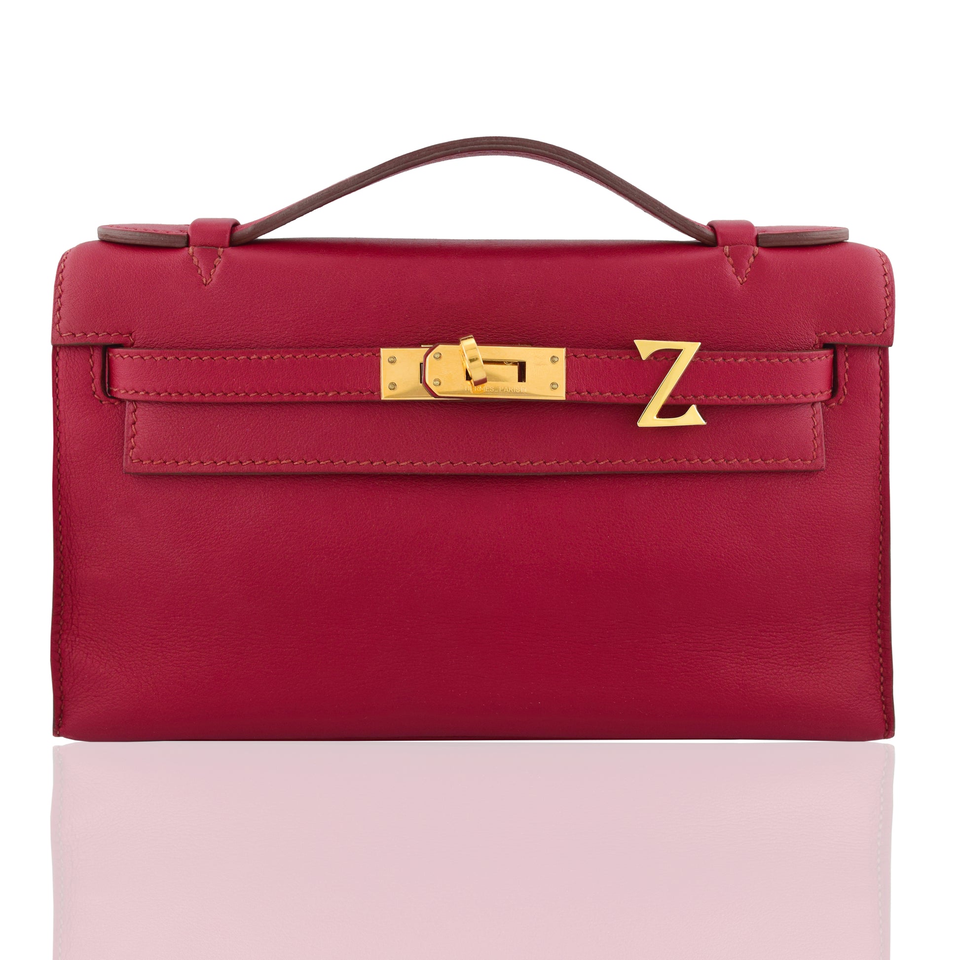 Red handbag with gold clasp on a white background, collection-preview